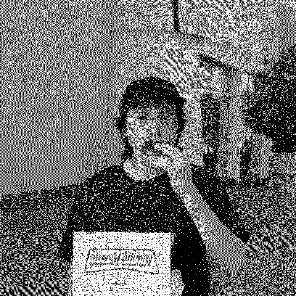 Black-and-white portrait of Ángel eating an alfajor.