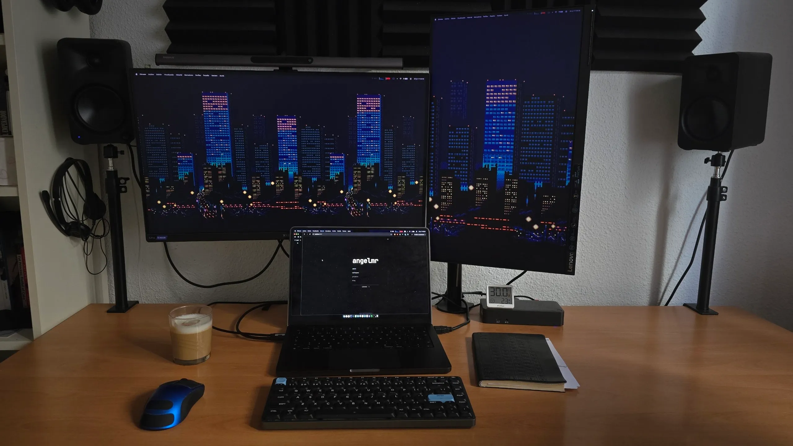 Ángel's desk setup with a laptop, two monitors, speakers, keyboard, and mouse.